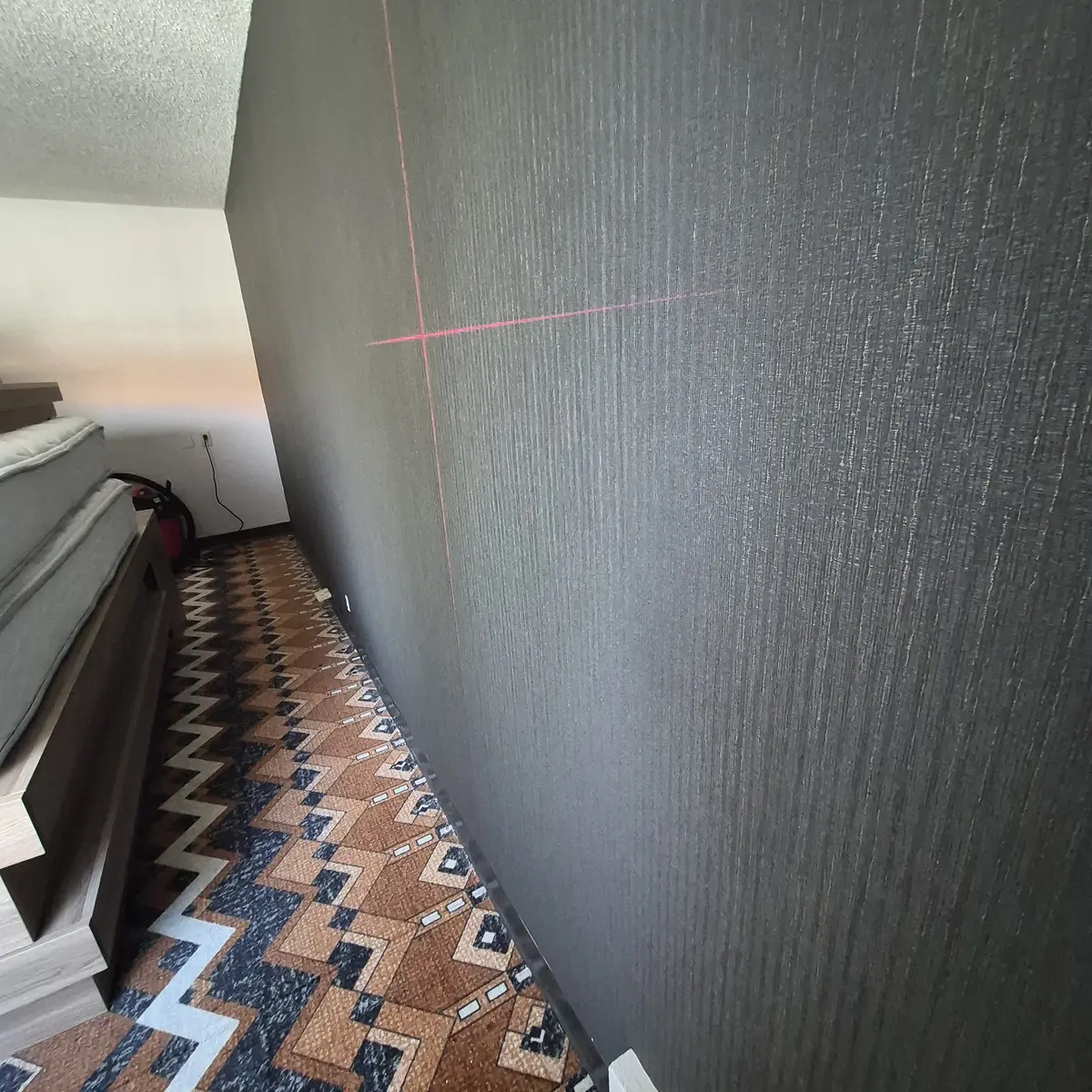 Finished dark accent wall with commercial vinyl wallcovering in Estes Park hotel guest room